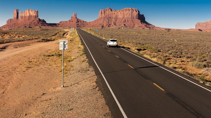 SUV drives toward Monument Valley on Utah Arizona border, American southwest. (Photo by: Visions of America/Universal Images Group via Getty Images)